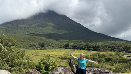 Reiziger bij de Arenal-vulkaan in het groene Costa Rica, met wolken rond de bergtop.
