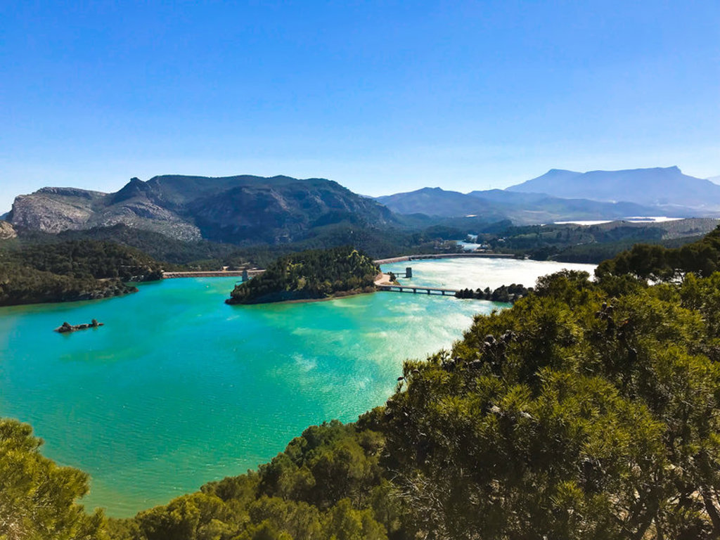 Turquoise stuwmeer tussen bergen en bossen in Andalusië, Spanje.