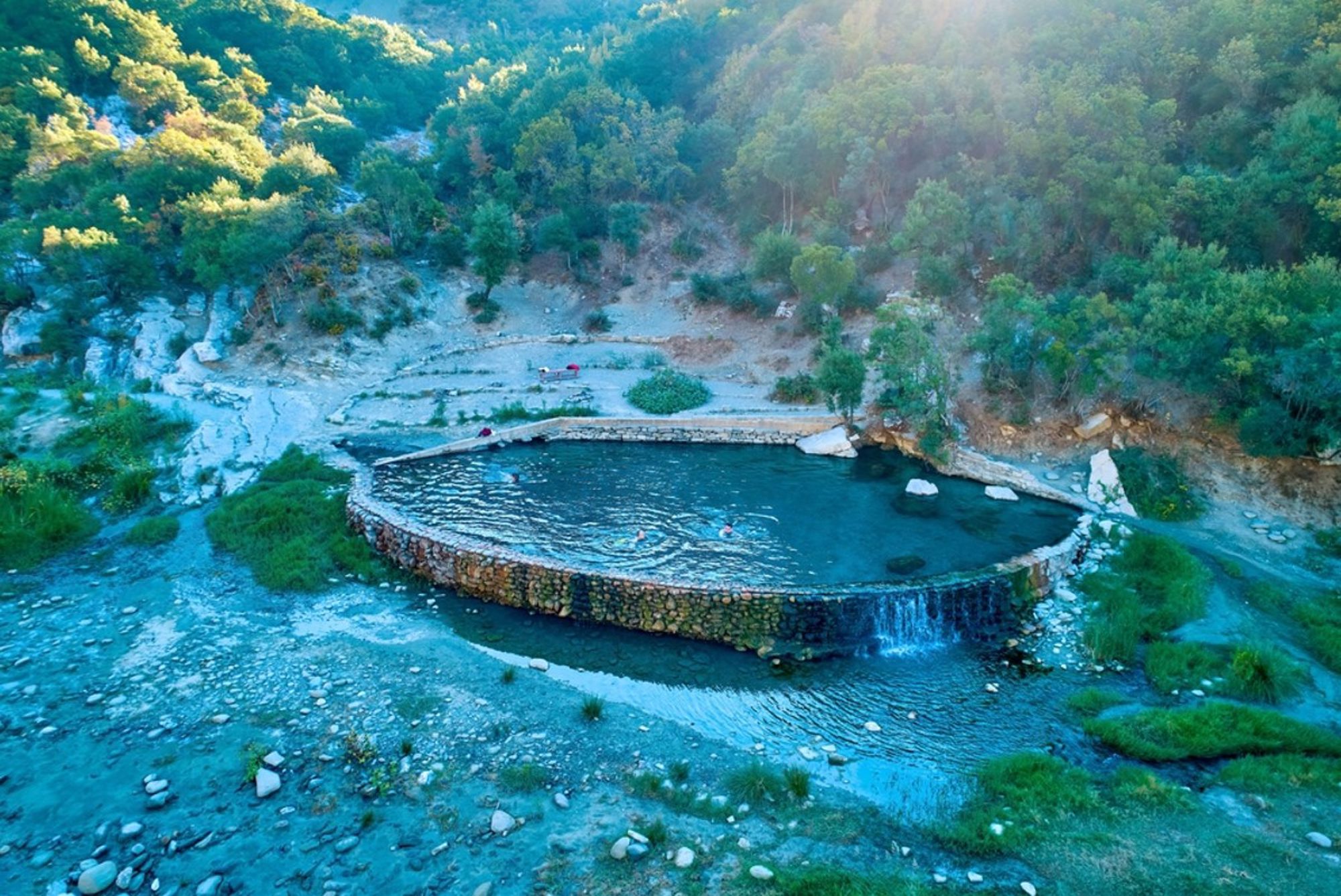 Natuurlijk zwembad met kleine waterval in een groene vallei in Albanië.
