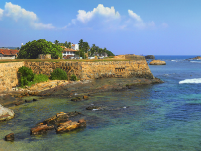 Kustlijn bij Galle met oude stadsmuur, palmbomen en turquoise zee in Sri Lanka.