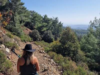 Wandelaar op bergpad met uitzicht over de groene heuvels op Cyprus tijdens de Cyprus familiereis.