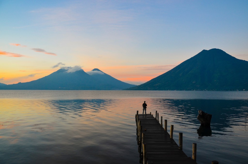 Zonsondergang bij het Meer van Atitlán met vulkanen en een houten steiger, Guatemala.