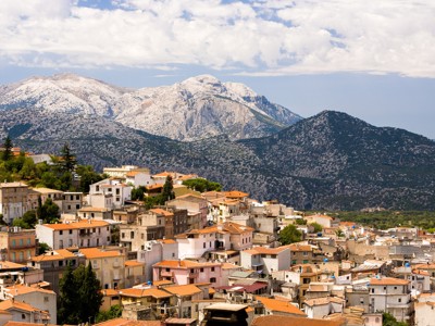 Uitzicht over een dorp met oranje daken en bergen op Sardinië tijdens route 8 daagse wandelvakantie, dag 1.