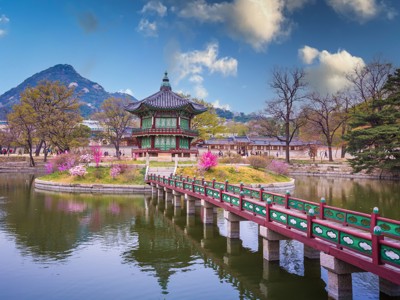 Gyeonghoeru-paviljoen in Gyeongbokgung-paleis, Seoul, met brug over vijver en bergen op de achtergrond.