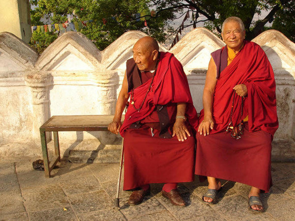 Twee boeddhistische monniken in rode gewaden bij een stupa in Nepal tijdens de groepsrondreis Nepal Everest.