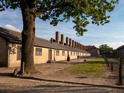 Blok 11 in Auschwitz-Birkenau met barakken en schoorstenen langs het pad, Polen.