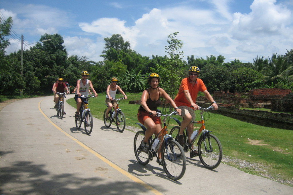 Fietstocht met reizigers door het groene landschap van Thailand tijdens groepsrondreis Noord en Zuid.