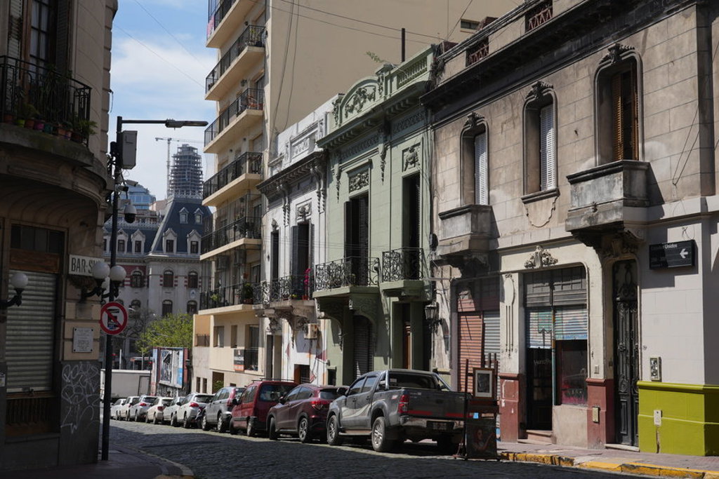 Straat in Buenos Aires met historische gevels, balkons en geparkeerde auto’s tijdens een groepsrondreis Argentinië.