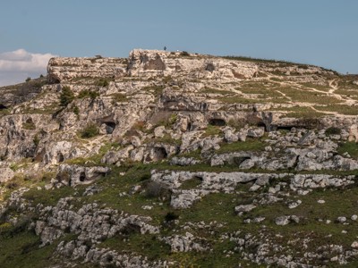 Kalkstenen rotslandschap met grotwoningen langs de route van Alberobello naar Matera in Puglia.