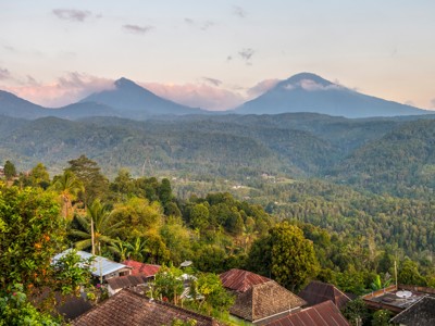Uitzicht op groene heuvels en vulkanen bij zonsopkomst op Bali, Indonesië.
