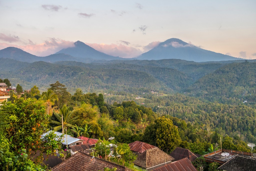 Uitzicht op groene heuvels en vulkanen bij zonsopkomst op Bali, Indonesië.