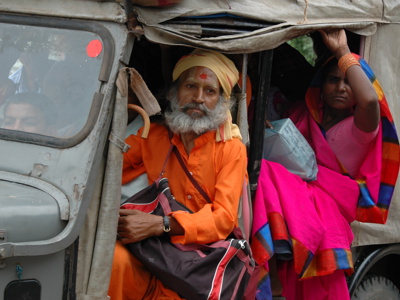 Reizigers in jeep in Orissa tijdens Route Orissa 23 dagen, met man in oranje en vrouw in roze sari.