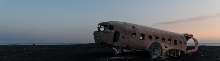 Solheimasandur Plane Wreck op het zwarte zandstrand van IJsland bij zonsondergang.