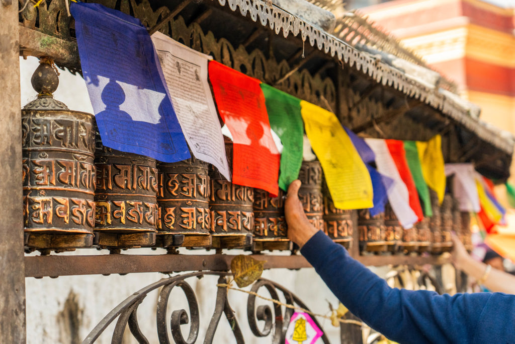 Gebedsmolens met kleurrijke gebedsvlaggen bij een boeddhistische tempel in Nepal.