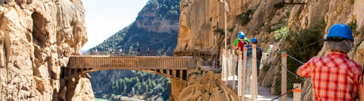 Wandelaars op de Caminito del Rey, een hangend wandelpad langs steile rotswanden in Spanje.