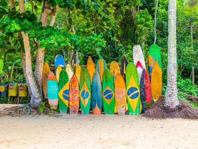 Kleurrijke surfplanken met Braziliaanse vlag tegen een houten hek aan de rand van het regenwoud in Brazilië.