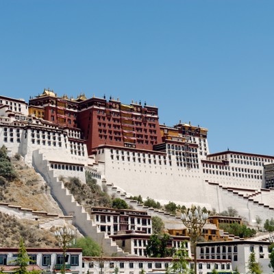 Potala-paleis in Lhasa, Tibet, op een heuvel onder een heldere blauwe lucht.