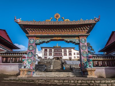 Kleurrijke boeddhistische poort met gebedsmolens bij een klooster op de Everest Base Camp-route in Nepal.