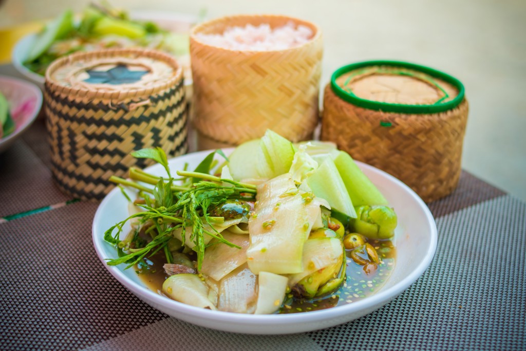 Thaise papajasalade met kleefrijst in bamboemandjes, tijdens 22-35ers reis Thailand, Laos & Cambodja.