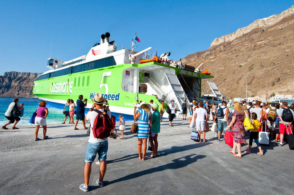 Reizigers stappen aan boord van de veerboot naar Santorini tijdens een familiereis Griekenland in de meivakantie.