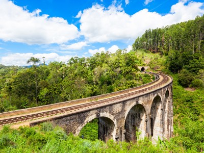 Negenbogenbrug met spoorlijn door de groene heuvels bij Ella op de Route Sri Lanka.
