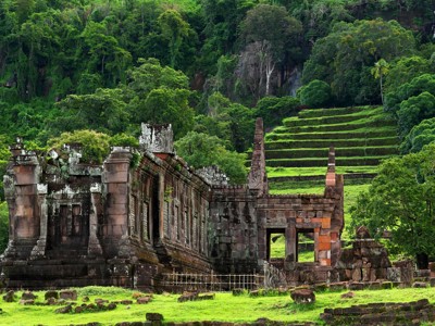 Tempelruïnes van Wat Phou bij Champasak, Laos, omringd door groene heuvels.
