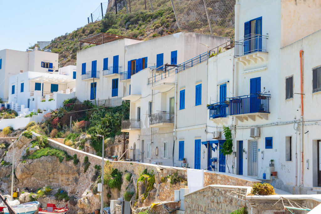 Witte huizen met blauwe luiken in een kustdorp in West-Sicilië, Italië.