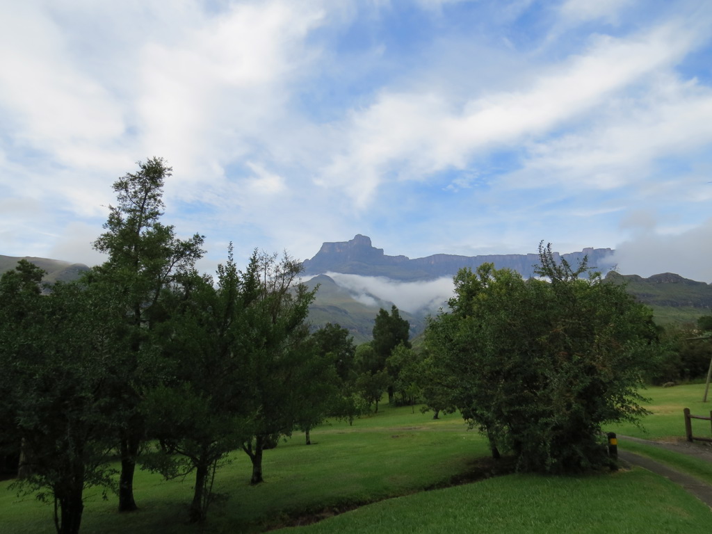 Groen berglandschap met wolkenslierten en rotsplateau in de verte tijdens groepsrondreis Zuid-Afrika, eSwatini en Lesotho.