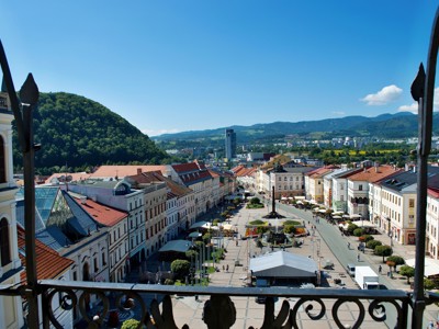 Uitzicht over het centrale plein en de hoofdstraat van Banská Bystrica, Slowakije, met bergen op de achtergrond.