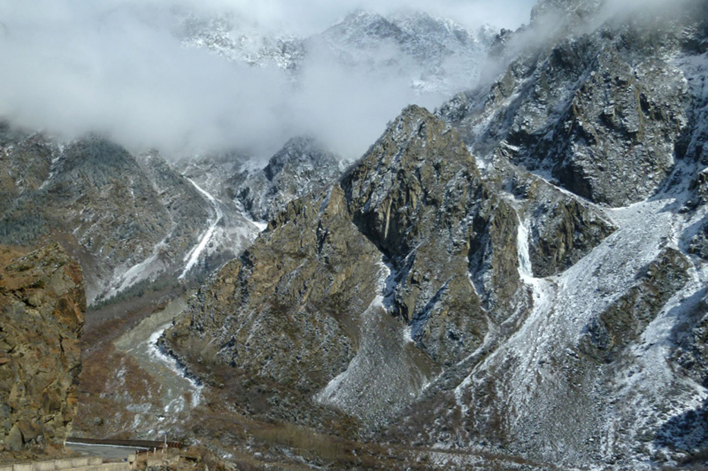 Berglandschap met besneeuwde bergtoppen en wolken in de Kaukasus, tijdens groepsrondreis Armenië en Georgië.