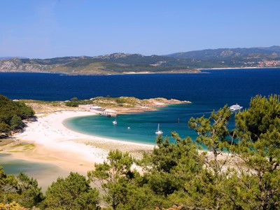 Uitzicht op een halvemaanvormig zandstrand en turquoise baai aan de kust van Galicië, Spanje.