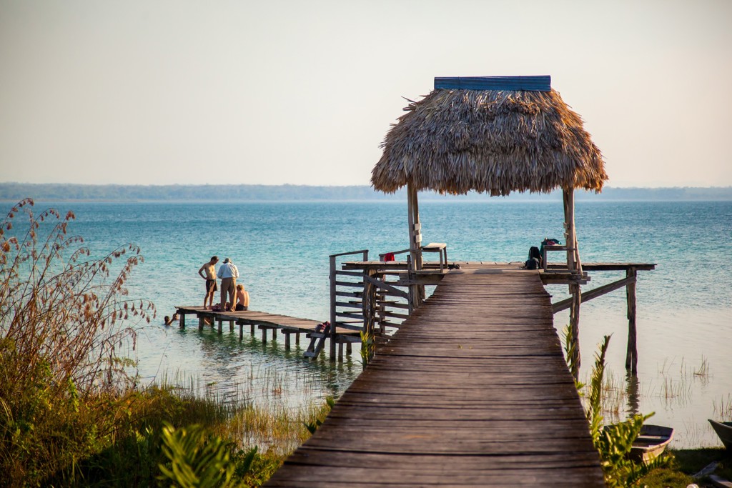 Houten steiger met rieten hut aan het water, stop tijdens familiereis Guatemala en Belize.