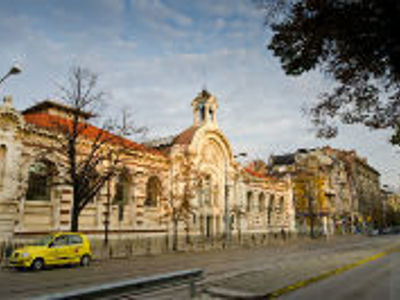 Historisch gebouw met booggevel in Plovdiv, Bulgarije, langs een brede straat.