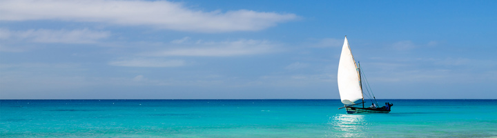 Zeilboot op helderblauwe zee voor de kust van Mozambique.