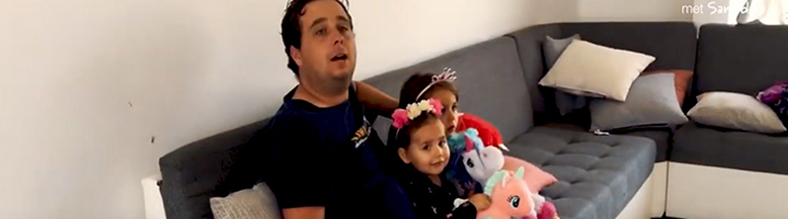 Reisbegeleider Tim met zijn familie op de bank in Ecuador, met de kinderen en knuffels.