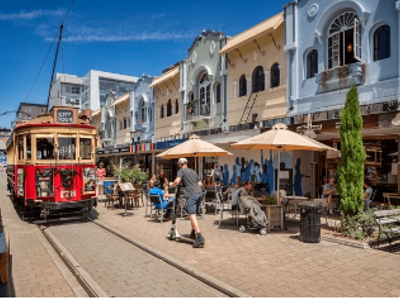 Tram in Christchurch langs terrassen en historische gevels op de Route Nieuw-Zeeland.