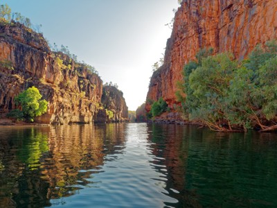 Rivierkloof met hoge rode rotswanden en groen langs het water in West-Australië.