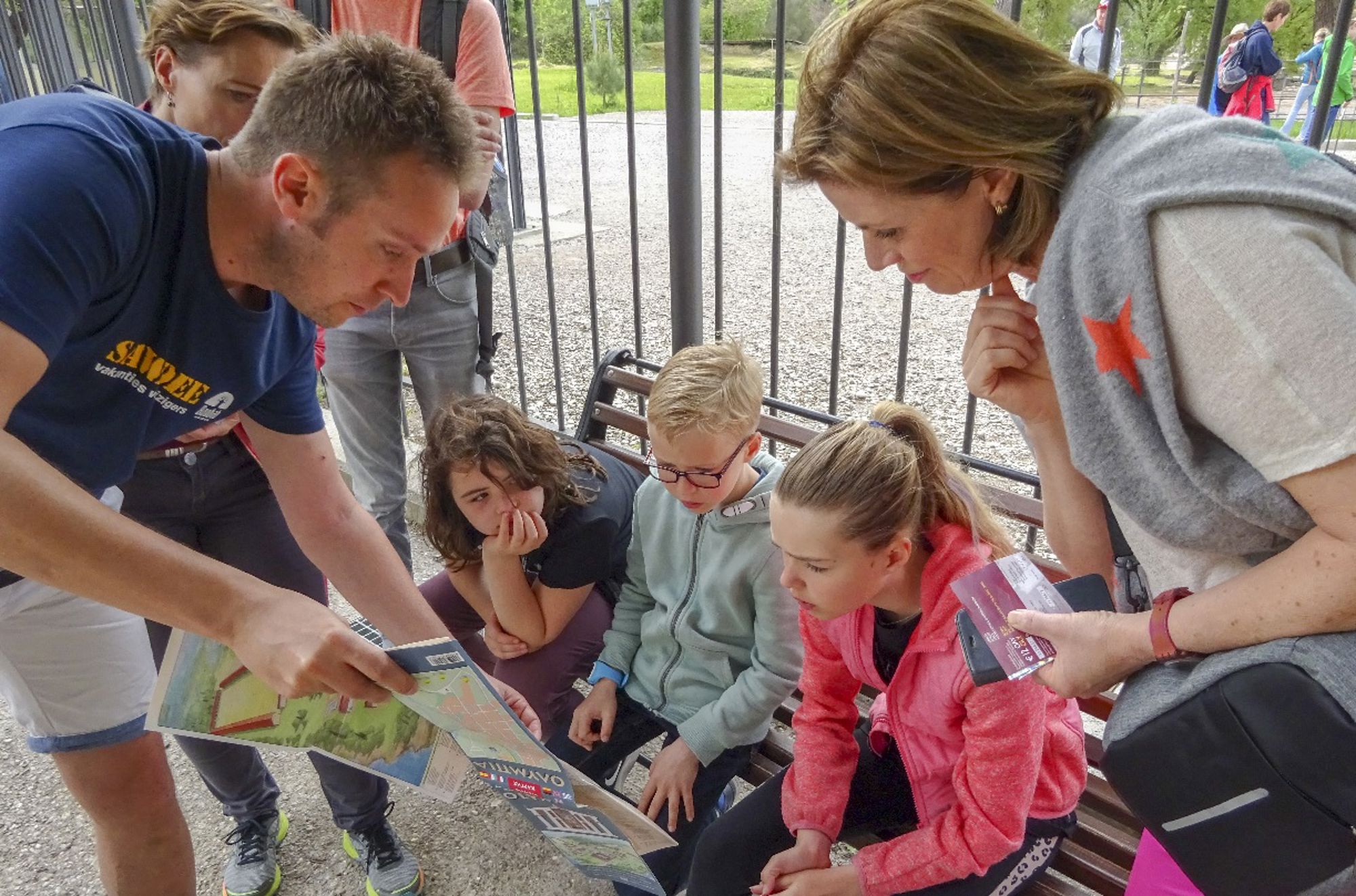 Kinderen en gids op reis Gezin bekijkt een plattegrond en tickets bij de ingang van een dierentuin.