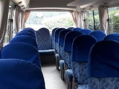 Interieur van een bus in Costa Rica met stoelen en bagagerek.