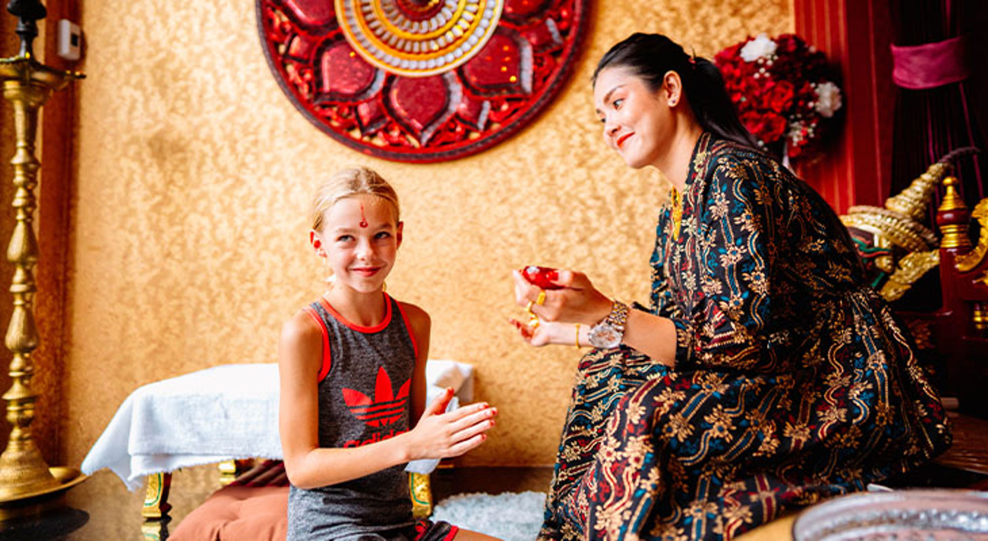 Cultuur Thailand Kind krijgt een traditionele versiering op het voorhoofd tijdens een verre reis met kinderen in de schoolvakantie.