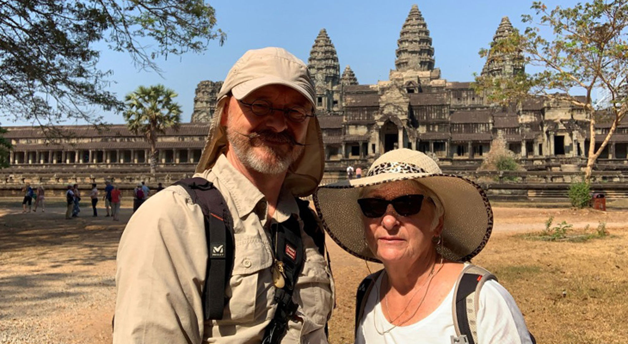 Luc en Chrisje in Cambodja Twee reizigers met zonnehoed en rugzak poseren voor de tempels van Angkor Wat in Cambodja.