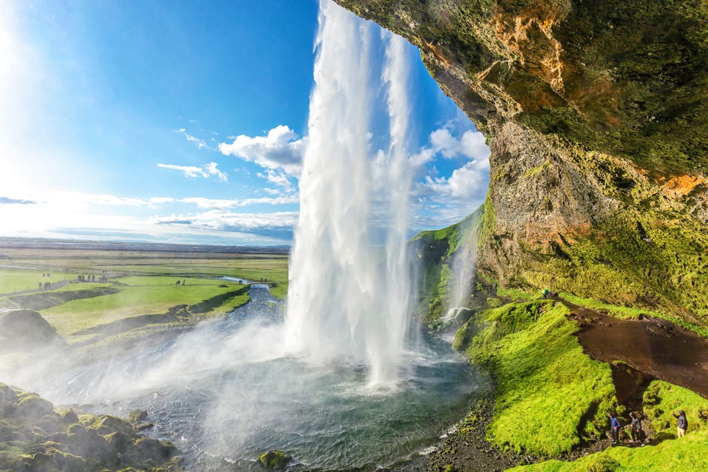 Seljalandsfoss-waterval in IJsland, gezien vanaf het pad achter de waterval tijdens een groepsrondreis kamperen.