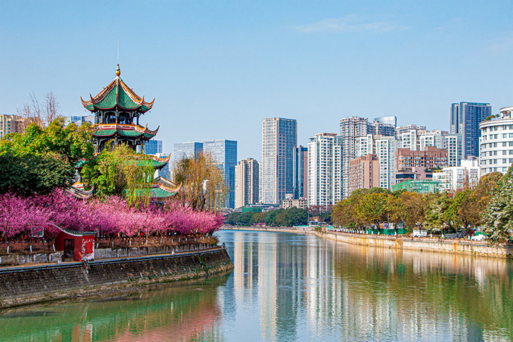 Traditionele pagode aan de rivier met moderne skyline, tijdens een familiereis door China.