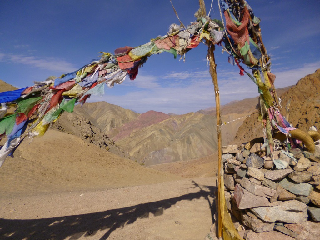 Gebedsvlaggen bij een bergpas in Ladakh, met uitzicht op ruige Himalaya-bergen tijdens de groepsrondreis India.