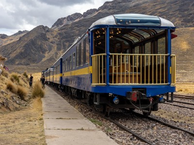 Blauw-gele trein bij een bergstation in de Andes tijdens de Route Peru.