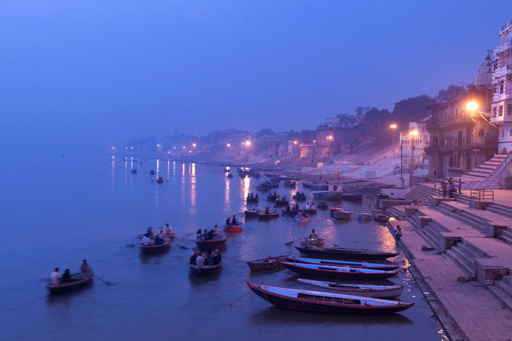 Avondzicht op de Ganges in Varanasi met boten langs de ghats, tijdens de groepsrondreis Noord-India Compleet.