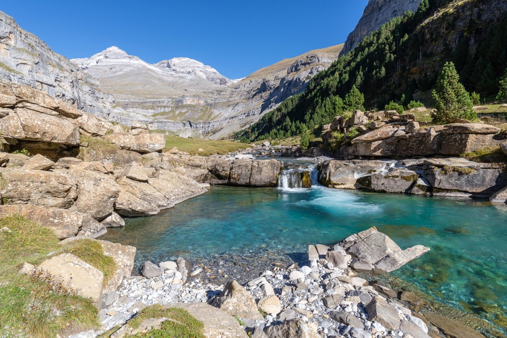 Berglandschap met helderblauw rivierbad en waterval tussen rotsen, tijdens familiereis Spanje & Portugal.