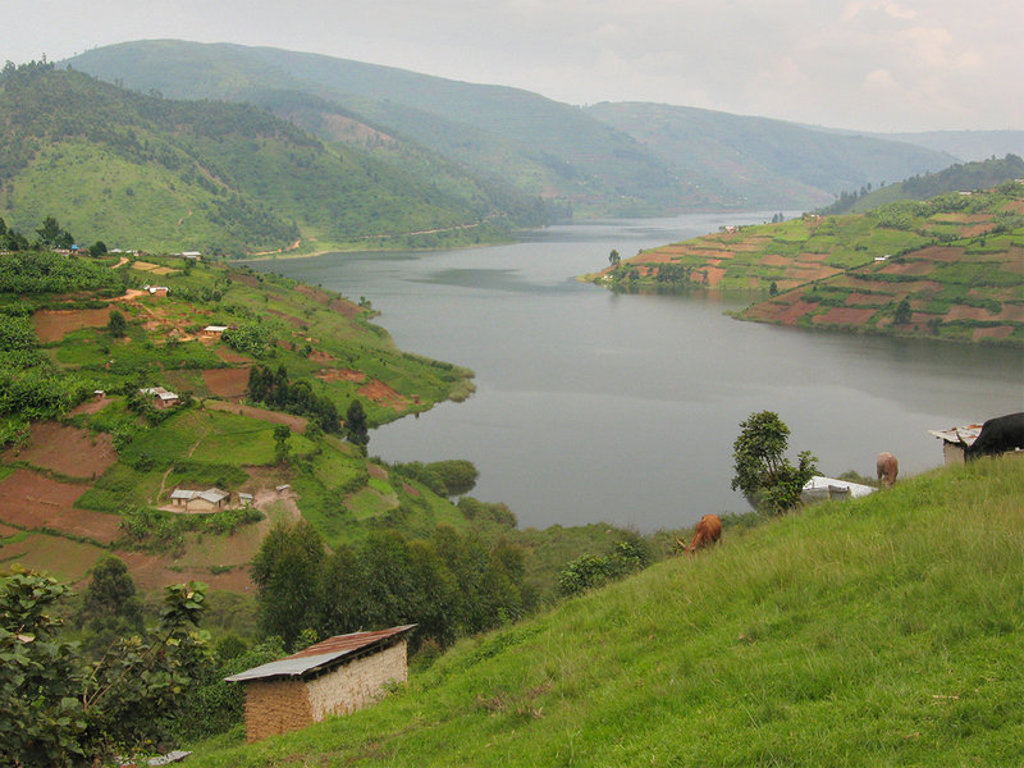 Groene heuvels en terrassen rond een meer in Uganda tijdens de groepsrondreis Uganda en Rwanda.