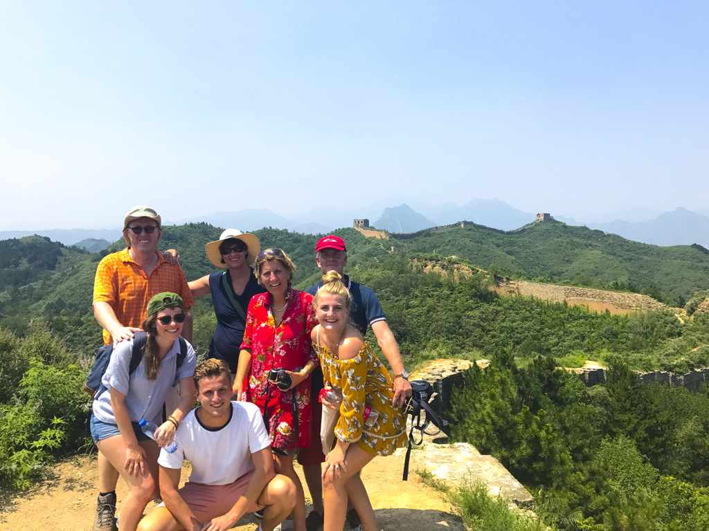 Familie poseert bij de Chinese Muur tijdens een familiereis door China.