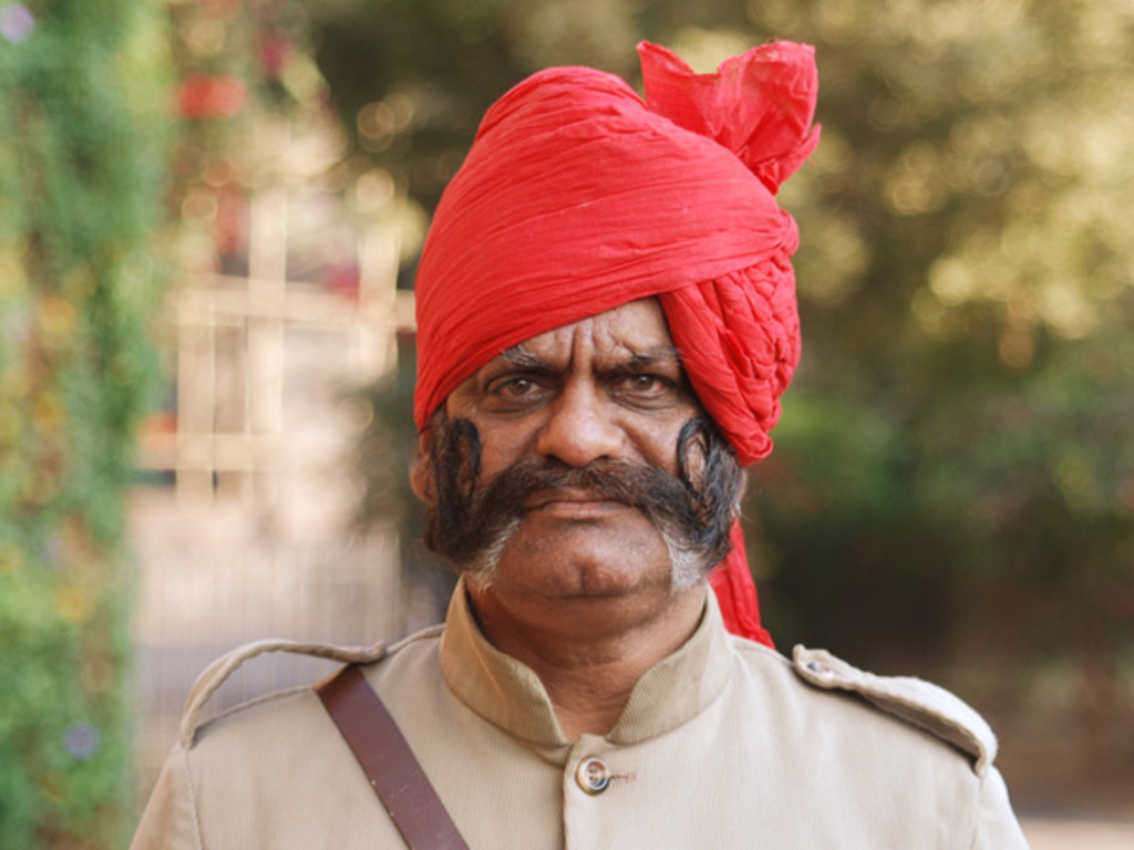 Portret van een man met rode tulband en opvallende snor tijdens de groepsrondreis Noord-India Compleet.